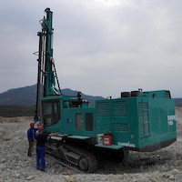 Track-mounted percussion drilling unit.